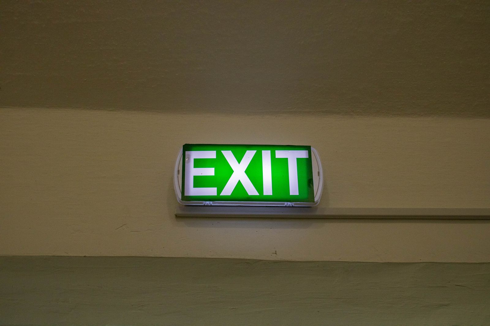 Sample image of a lit green exit sign on a corridor wall